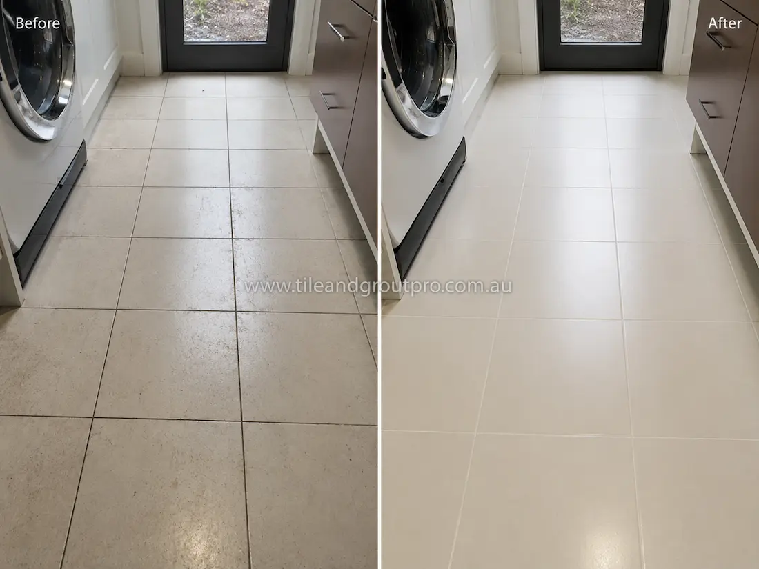 Before tile renewal, the laundry ceramic floor tiles had visible dirt buildup, dull grout lines, and a faded finish in a compact laundry room.