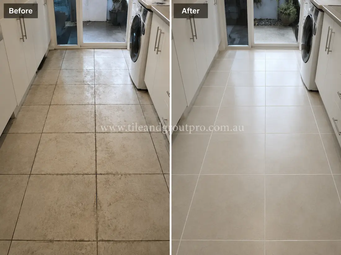 Before tile renewal, the laundry porcelain floor tiles showed dirty grout lines, surface staining, and dull patches in a residential laundry room.
