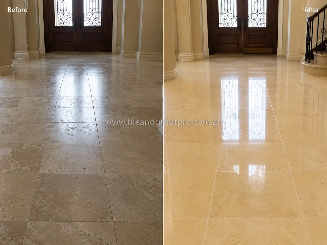 Before tile renewal, the polished limestone foyer floor had a hazy finish with visible wear and reduced reflectivity in a luxury home entrance.