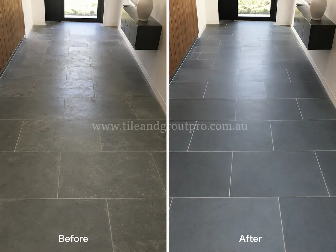 Before tile renewal, indoor bluestone floor tiles in a modern entry hallway looked dull and worn with cloudy patches, light etching, and uneven surface finish under natural lighting.