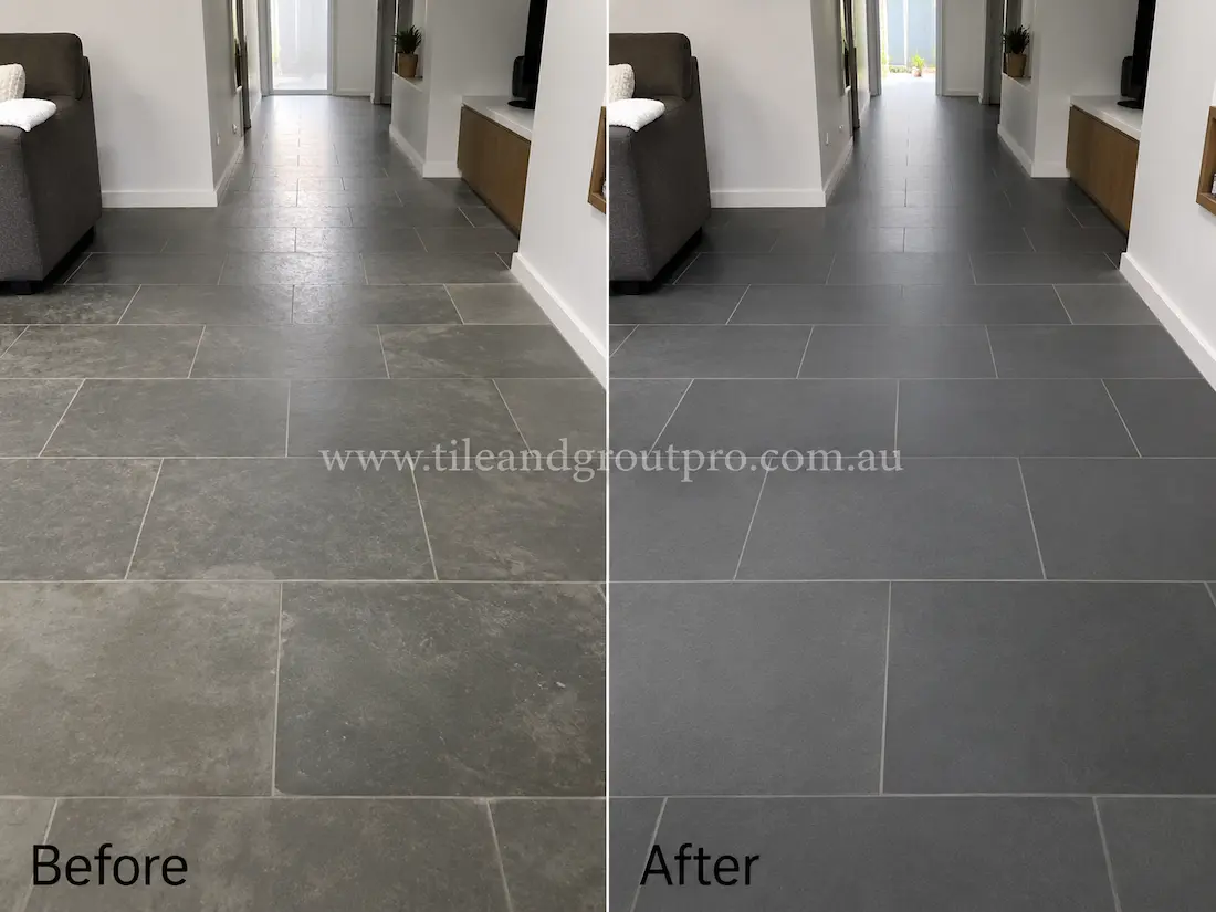 Before tile renewal, indoor bluestone floor tiles in a modern living room and hallway showed dull patches, residue buildup, and a worn matte appearance under natural indoor lighting.