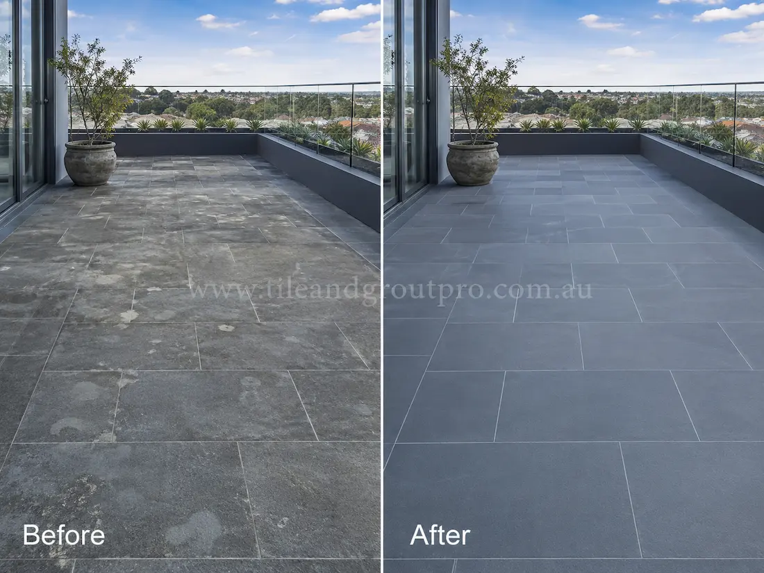 Before tile renewal, outdoor bluestone balcony tiles on a modern penthouse terrace appeared faded and patchy with surface haze, mineral staining, and uneven colouring across the stone floor.