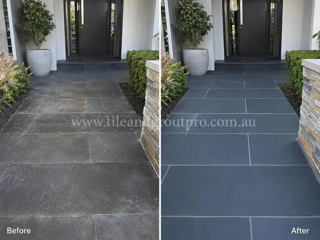 Before tile renewal, outdoor bluestone entryway tiles at a modern home entrance showed chalky residue, dull patches, and weathered natural stone surfaces around the front doorway.