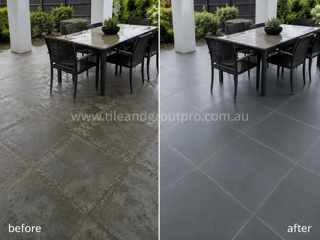 Before tile renewal, dark bluestone patio tiles in a covered outdoor entertainment area looked worn and blotchy with moisture marks, dirt buildup, and reduced stone depth around the dining furniture.