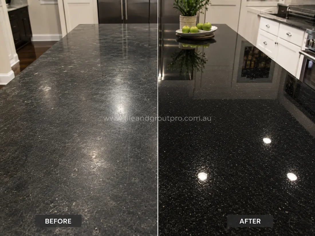 Black granite kitchen benchtop before grinding, featuring visible scratches, surface haze, and worn polish across the countertop island in the modern kitchen.