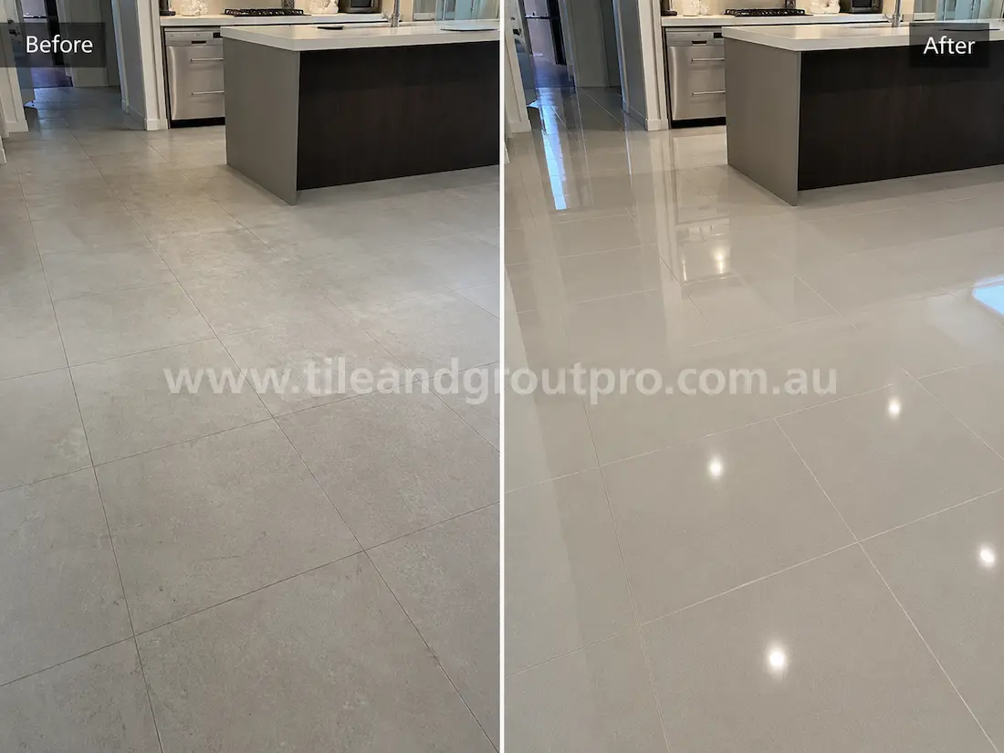 Before stone-polishing of light porcelain kitchen floor tiles with a faded finish, minor surface marks, and low gloss around the kitchen island and walkways.
