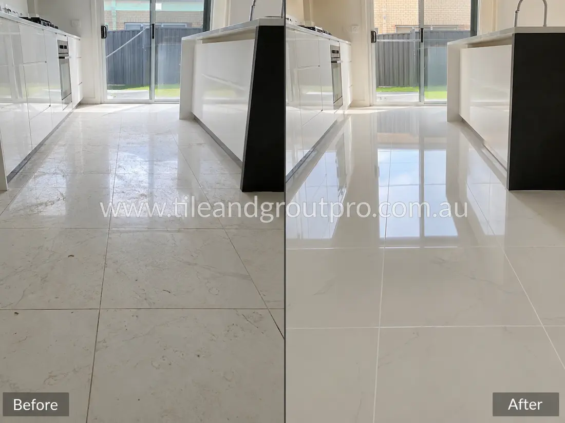 Before tile renewal, polished marble-look porcelain floor tiles in a modern kitchen displayed light soiling, surface haze, and reduced reflectivity, leaving the floor looking less bright and polished.