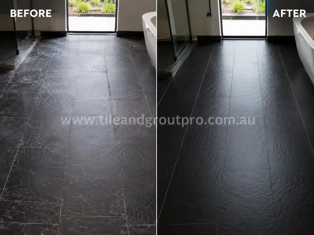 Black slate bathroom floor tiles with visible scuff marks and surface scratches before professional scratch removal and surface restoration.