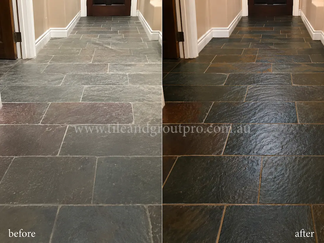 Before tile renewal, natural slate kitchen floor tiles showed a faded appearance, loss of colour depth, and dull stone surfaces in a residential kitchen with cabinetry and adjoining timber flooring.