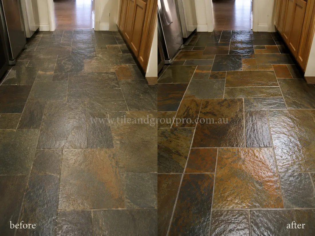 Before stone polishing, a slate tile kitchen floor showed a faded finish, reduced colour variation, and a dull surface across rectangular slate tiles between timber cabinetry and stainless-steel appliances.