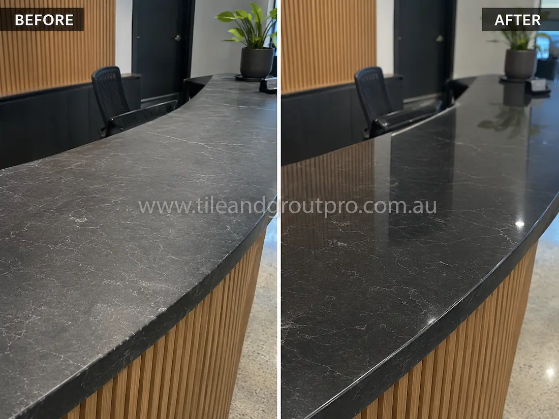 Before stone-polishing, the curved soapstone reception counter had a dry, matte appearance with visible surface wear and muted veining in a modern commercial interior.