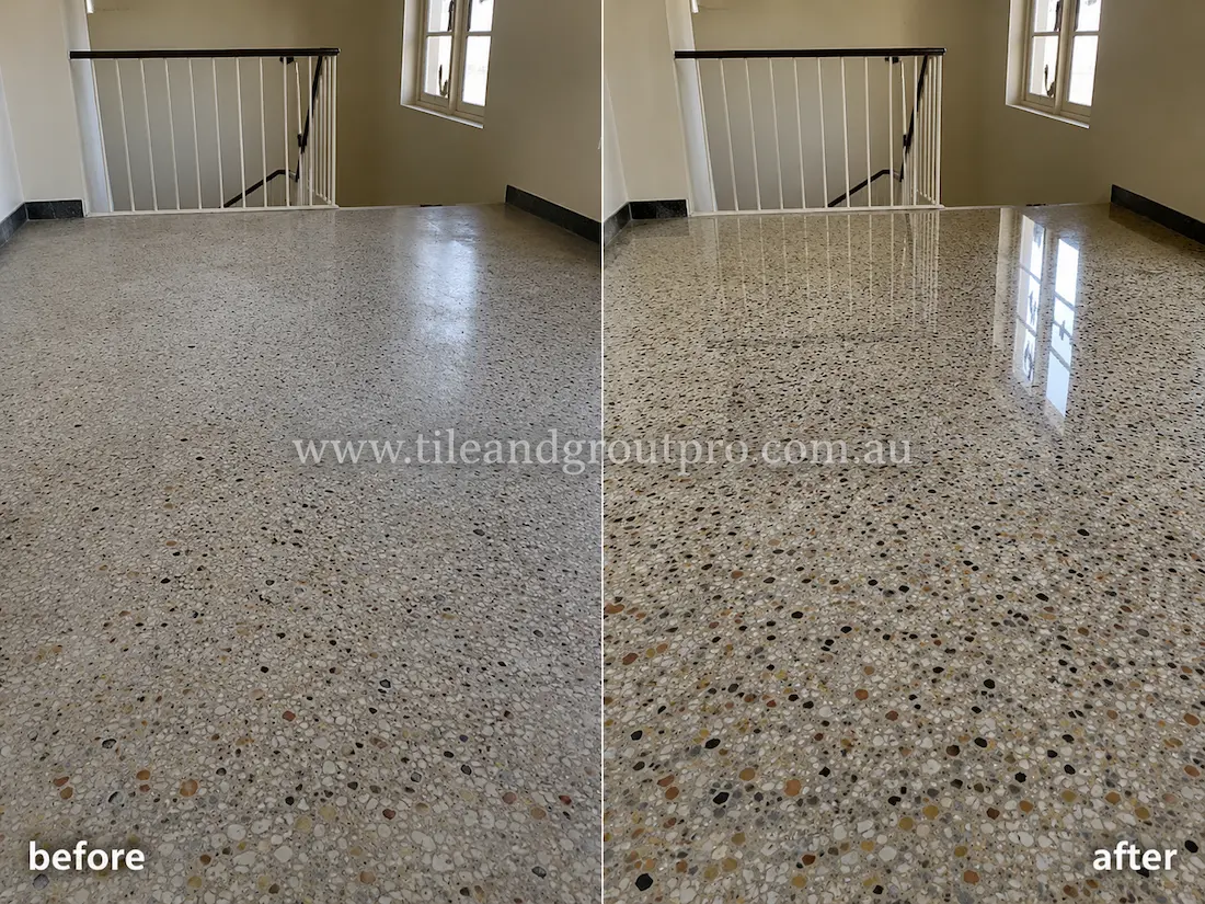 Before stone polishing, the terrazzo stair landing floor looked faded and matte with reduced clarity in the stone aggregate near a staircase railing and window.