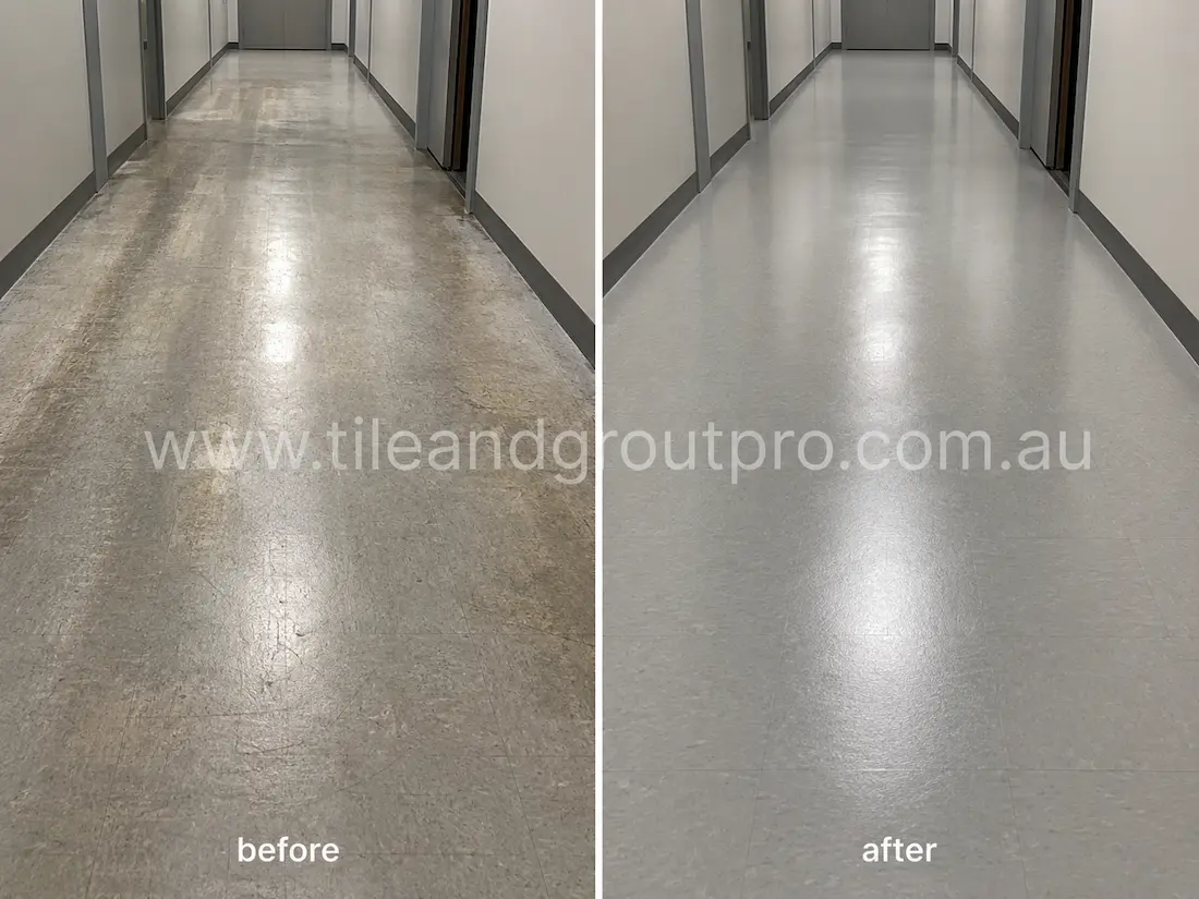 Commercial corridor with grey VCT flooring before sealer stripping, showing worn finish, discoloration, traffic marks, and uneven sealer build-up along the hallway surface.