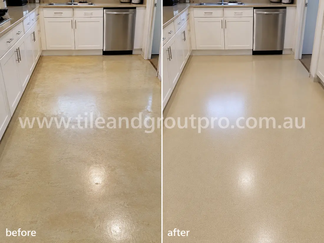 Residential kitchen with beige vinyl flooring before sealer stripping, featuring yellowed sealer residue, dull patches, and uneven surface shine around cabinets and appliances.