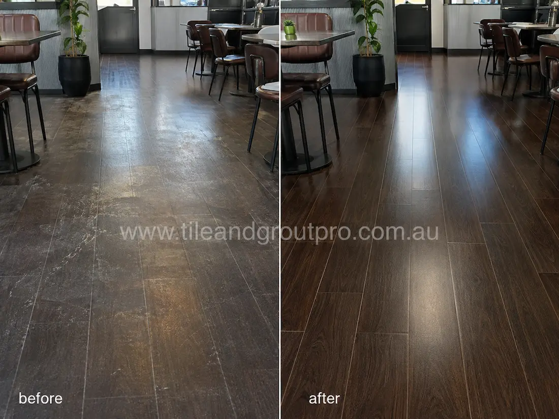 Restaurant dining area with dark wood-look floor tiles before sealer stripping, showing cloudy residue, worn coating, and patchy finish around tables and seating areas.