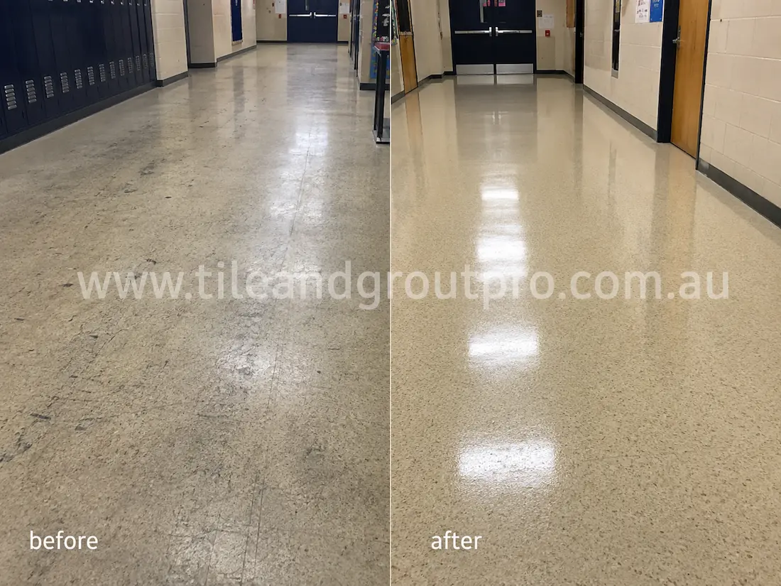 School corridor with VCT flooring before sealer stripping, displaying heavy foot traffic wear, faded finish, scuff marks, and uneven shine near lockers and classroom doors.